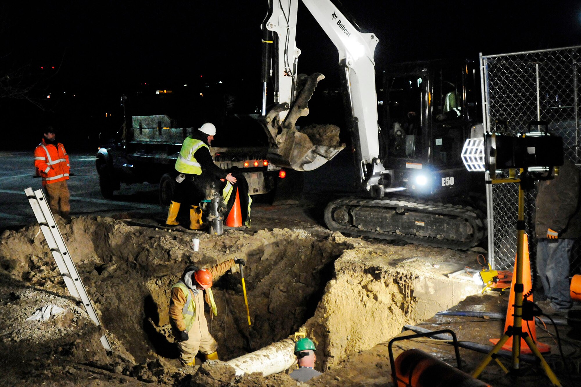 HANSCOM AIR FORCE BASE, Mass. – Civil engineering crews work in the dark and battle frigid temperatures to repair a water line break near the Education and Training Center parking lot. Several base and Hanscom Field buildings were temporarily without water while crews worked fast to repair the break. (U.S. Air Force photo by Linda LaBonte Britt)