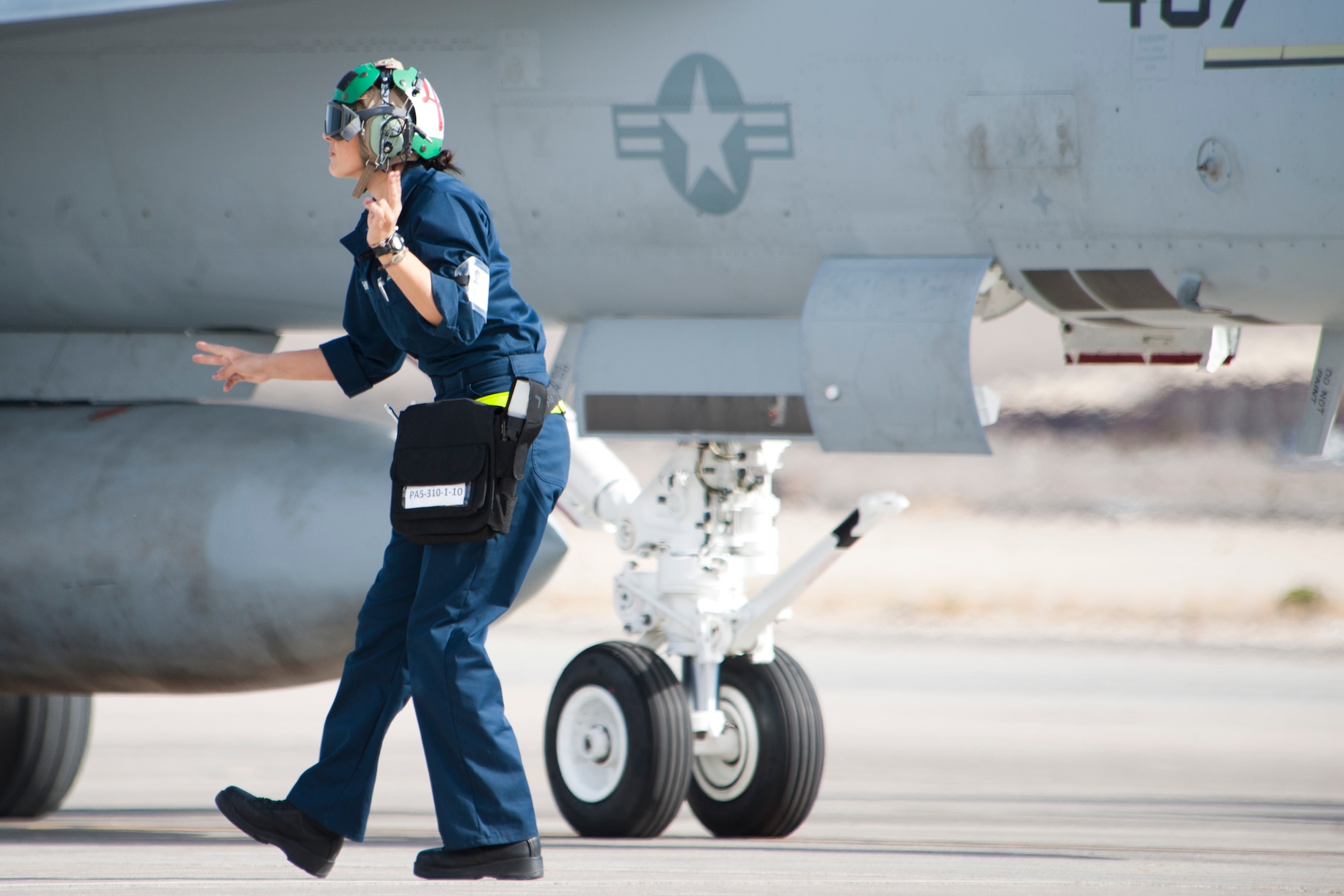 U.S. Navy Petty Officer 3rd Class Colleen Shine, Strike Fighter Squadron 25 (VFA-25), Naval Air Station, Lemoore, Calif., plane captain, signals to an F/A-18E Hornet pilot to power up the aircraft engines prior to taxiing onto the Nellis Air Force Base, Nev. flight line Jan. 25, 2013. The VFA-25 participation in Red Flag 13-2 trains ground workers and aircrews on joint and allied air forces on realistic threat tactics. (U.S. Air Force photo by Lawrence Crespo) 