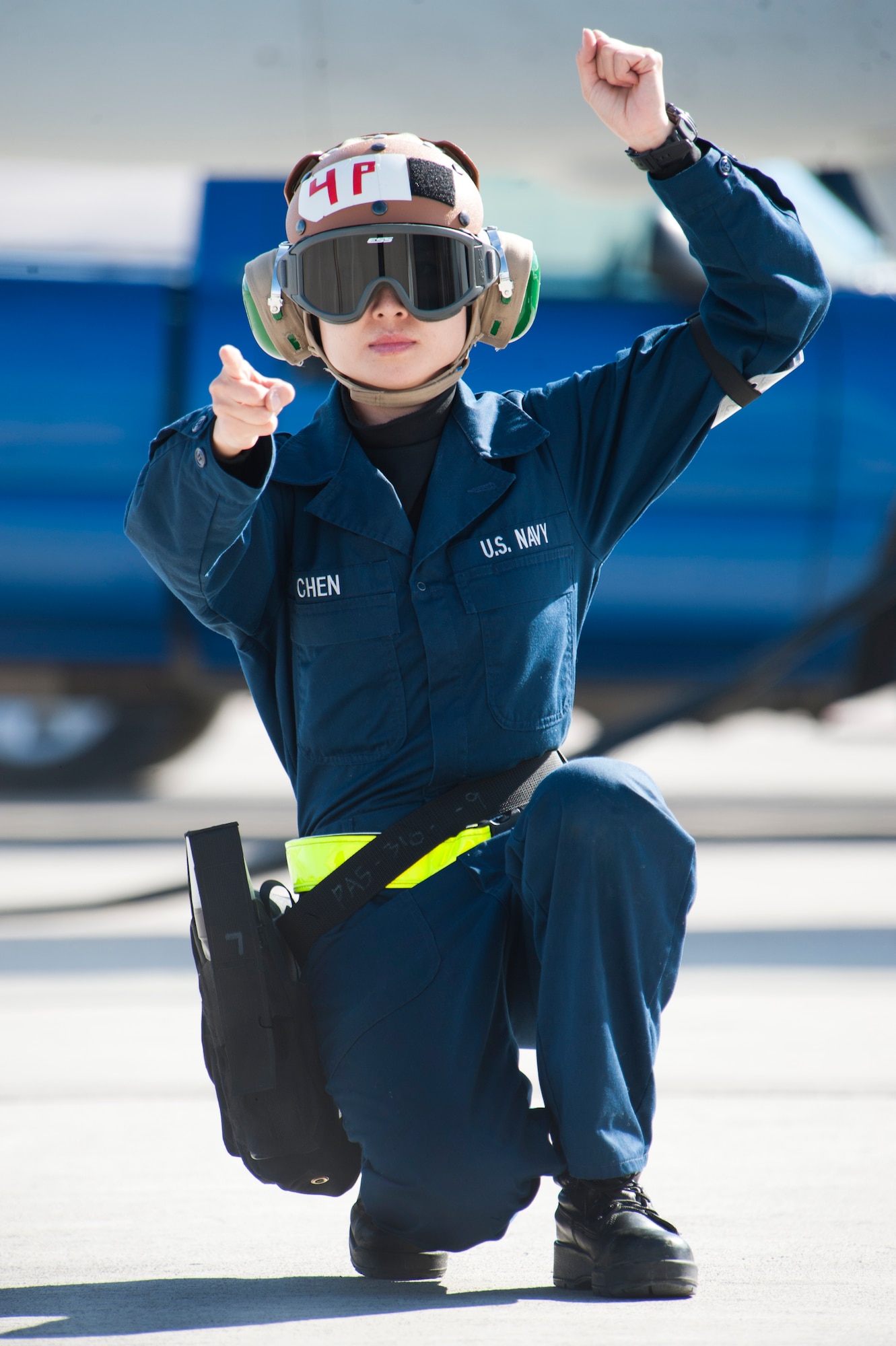 U.S. Navy Airman Zhou Chen, Strike Fighter Squadron 25 (VFA-25), Naval Air Station, Lemoore, Calif., plane captain, signals to an F/A18E Hornet pilot to hold safely on the Nellis Air Force Base, Nev. flight line Jan. 25, 2013.  The VFA-25 participation in the U.S. Air Force's Red Flag exercise builds allied air force cooperation and mutual support. (U.S. Air Force photo by Lawrence Crespo)