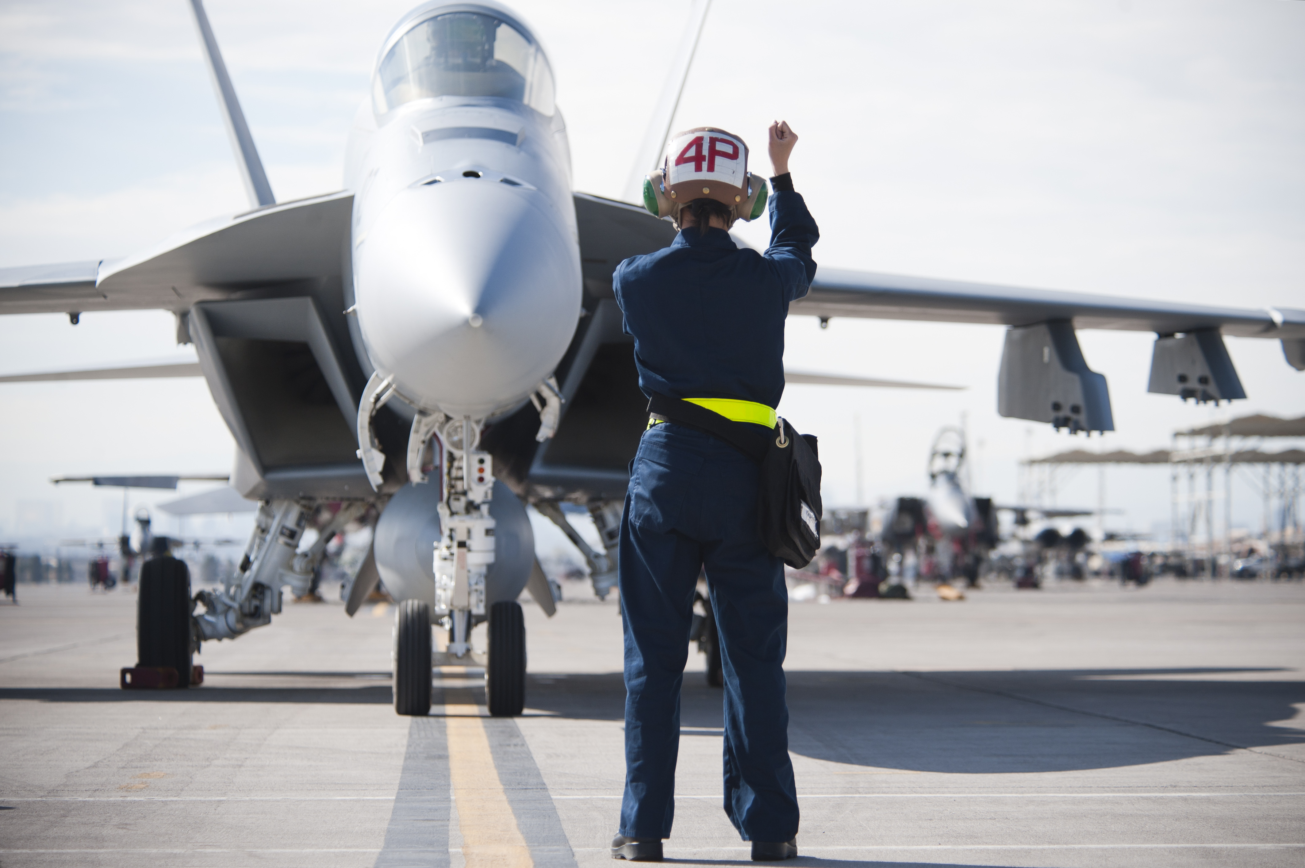 Navy ground crews communicate with pilots via hand signals