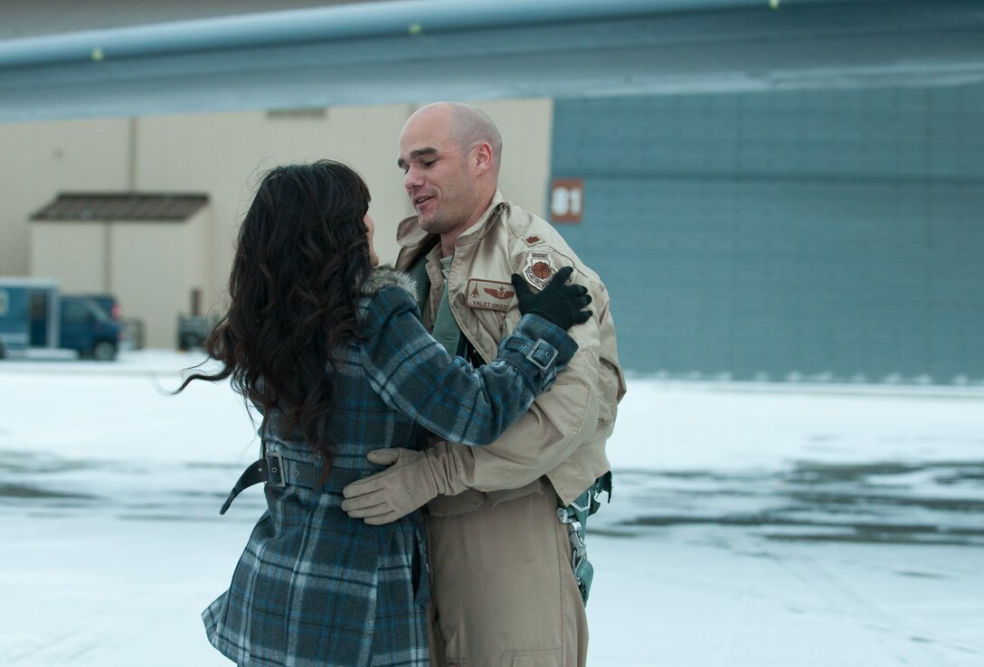 Maj. Patrick Okeefe, 37th Bomb Squadron weapon systems officer, hugs his wife, Jenifer Okeefe, after returning from a six month deployment in Southwest Asia at Ellsworth Air Force Base, S.D., Jan. 23, 2013. The aircrews deployed to Southwest Asia to conduct B-1 missions designed to deliver precision and non-precision weapons against adversaries. (U.S. Air Force photo by Airman 1st Class Alystria Maurer/Released)