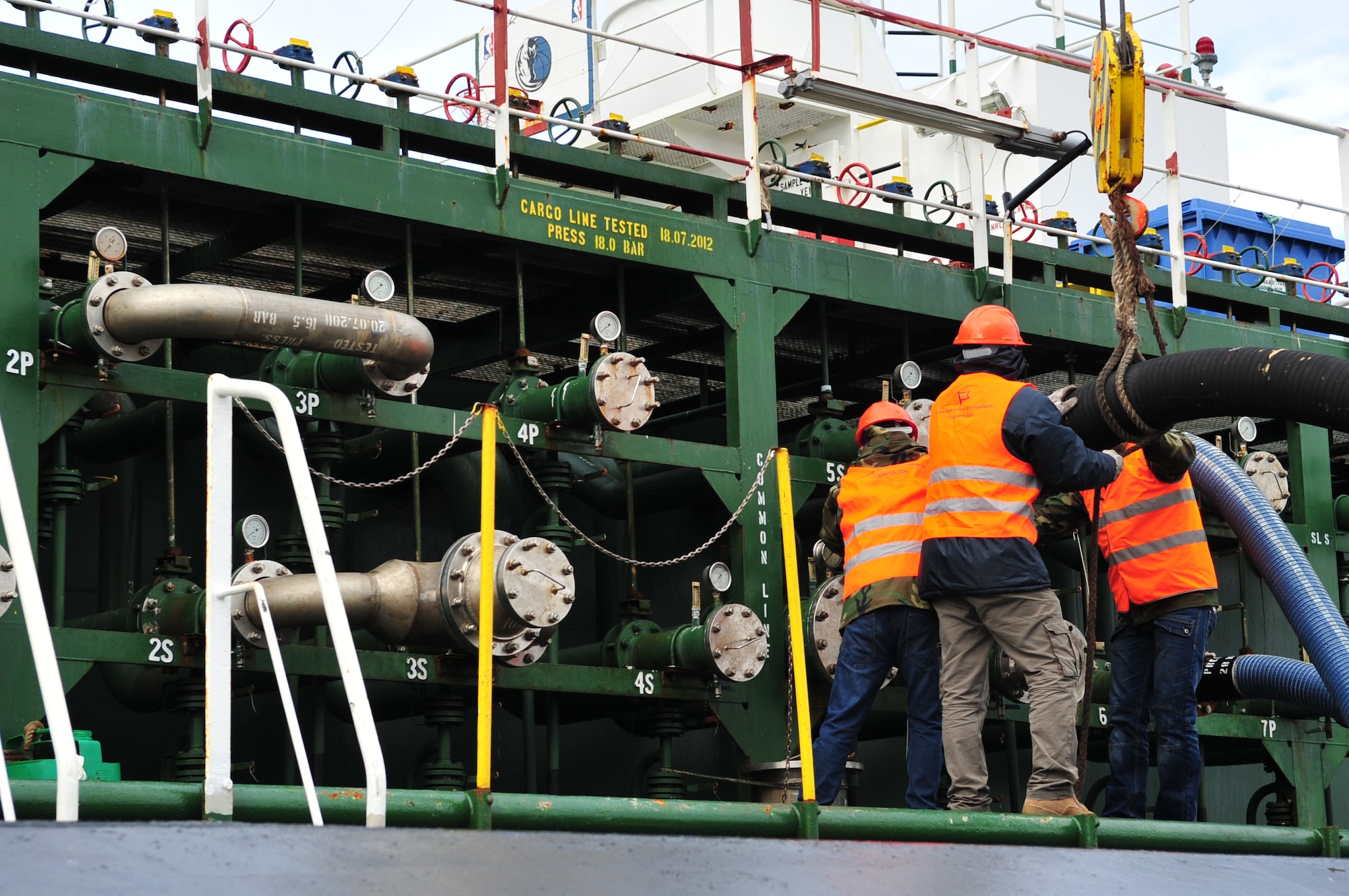 Contractors from Oceanica, attach a hose to a fuel tanker at Praia Bay, Azores, Jan. 29.  The fuel tanker delivered 220K gallons of unleaded fuel used to support our military and privately owned vehicles.  (U.S. Air Force photo by Tech. Sgt. Chenzira Mallory)