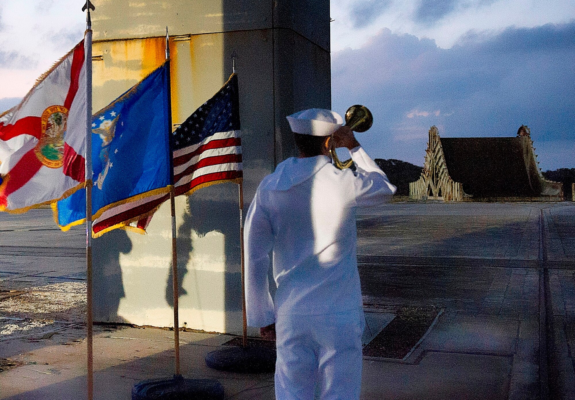 At exactly 6:31 p.m., a bugler from the Naval Ordnance Test Unit plays taps. That is the exact time the flash fire occurred, killing all three astronauts. (U.S. Air Force Photo/ Matthew Jurgens) 
