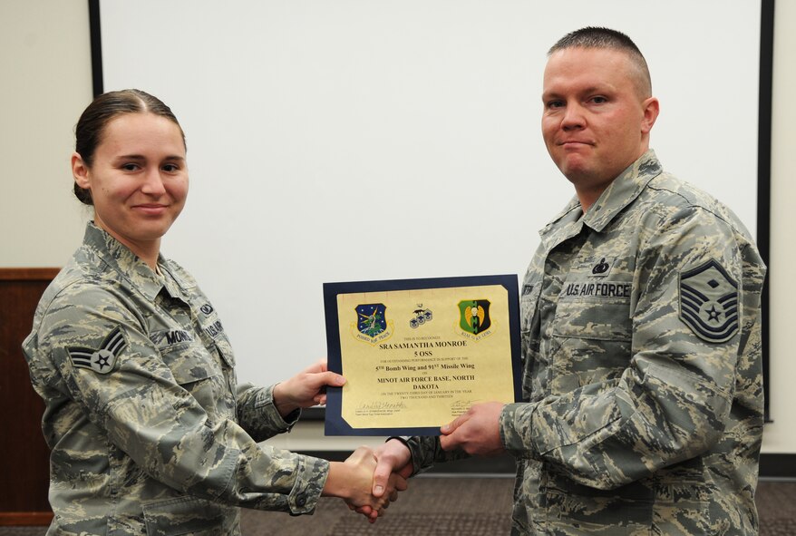 MINOT AIR FORCE BASE, N.D. -- Senior Airman Samantha Monroe, 5th Operations Support Squadron aircrew flight equipment journeyman, receives an award from the Minot Top 3 for her excellence in performing day-to-day operations here, Jan. 23. Monroe recently led the AFE portion of the 5th Operations Group Spouses' Orientation Tour. She demonstrated the usage of life saving equipment used by 5th Bomb Wing aircrew members to the spouses group. Her exceptional briefing garnered her accolades from all attendees. In addition, Monroe also served as SARC Victim Advocate for Minot AFB and provided stand-by response to Team Minot and the local VA community as focal point for sexual assault incidents. (U.S. Air Force photo/Senior Airman Brittany Y. Auld)