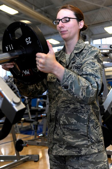 Senior Airman Cassandra Bridges, 28th Force Support Squadron Bellamy Fitness Center fitness specialist, removes a weight from a fitness machine before re-racking it in the Bellamy Fitness Center at Ellsworth Air Force Base, S.D., Jan. 25, 2013. The Bellamy Fitness Center staff won the Air Combat Command award for best fitness and sports program for the second year in a row. (U.S. Air Force photo by Airman Ashley J. Thum/Released) 