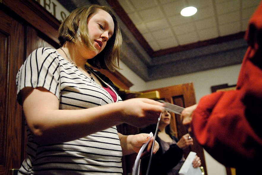 MINOT, N.D. -- Airman 1st Class Danielle Vickman, a paralegal at Minot Air Force Base, N.D., hands a ticket stub back to a patron of the Minot Symphony Orchestra's annual family concert at Ann Nicole Nelson Hall here, Jan. 26. Ten Airmen from the base volunteered as ushers for the concert. Volunteers are still needed for the next concert, which is scheduled for March 2. (U.S. Air Force photo/2nd Lt. Jose Davis)