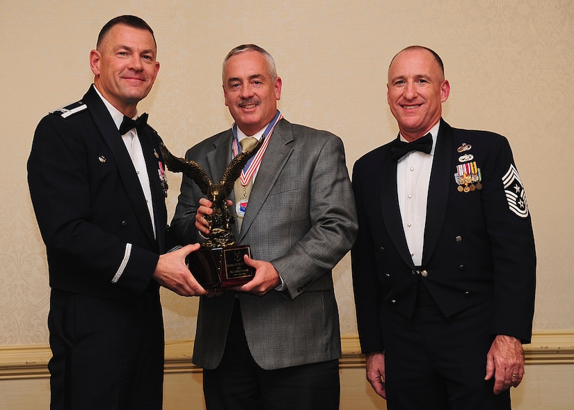 Colonel Richard McComb, Joint Base Charleston commander, and Chief Master Sgt. Al Hannon, 628th Air Base Wing command chief, present the JB Charleston Civilian Category III of the Year award to Jeffrey Garrett, 628th Civil Engineer Squadron chief of asset management flight, during the 628th Air Base Wing Annual Awards Banquet held at the Charleston Club, Jan. 25, 2013, at JB Charleston - Air Base, S.C. (U.S. Air Force photo/Staff Sgt. Rasheen Douglas)