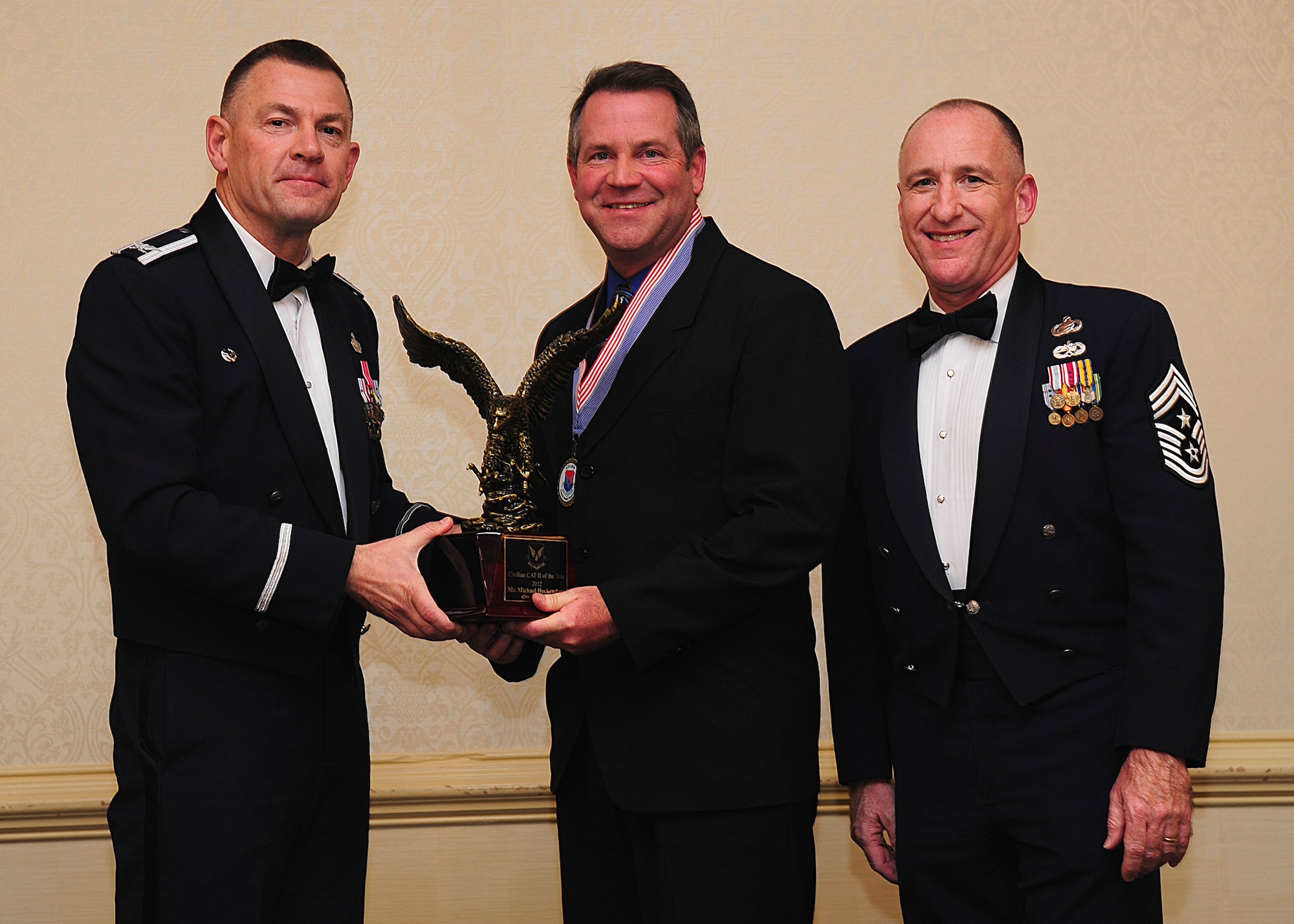 Colonel Richard McComb, Joint Base Charleston commander, and Chief Master Sgt. Al Hannon, 628th Air Base Wing command chief, present the JB Charleston Civilian Category II of the Year award to Michael Heckendorn, 628th Communications Squadron telecommunications project manager, during the 628th ABW Annual Awards Banquet held at the Charleston Club, Jan. 25, 2013, at JB Charleston - Air Base, S.C. (U.S. Air Force photo/Staff Sgt. Rasheen Douglas)