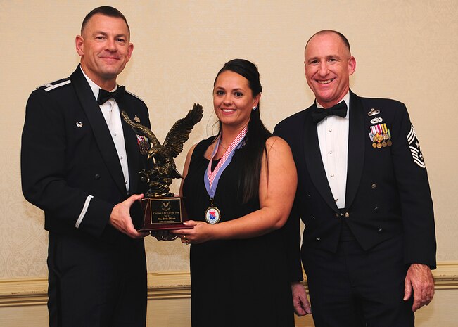 Colonel Richard McComb, Joint Base Charleston commander, and Chief Master Sgt. Al Hannon, 628th Air Base Wing command chief, present the JB Charleston Civilian Category I of the Year award to Beth Dixon, 628th Security Forces Squadron unit program coordinator, during the 628th ABW Annual Awards Banquet held at the Charleston Club, Jan. 25, 2013, at JB Charleston - Air Base, S.C. (U.S. Air Force photo/Staff Sgt. Rasheen Douglas)