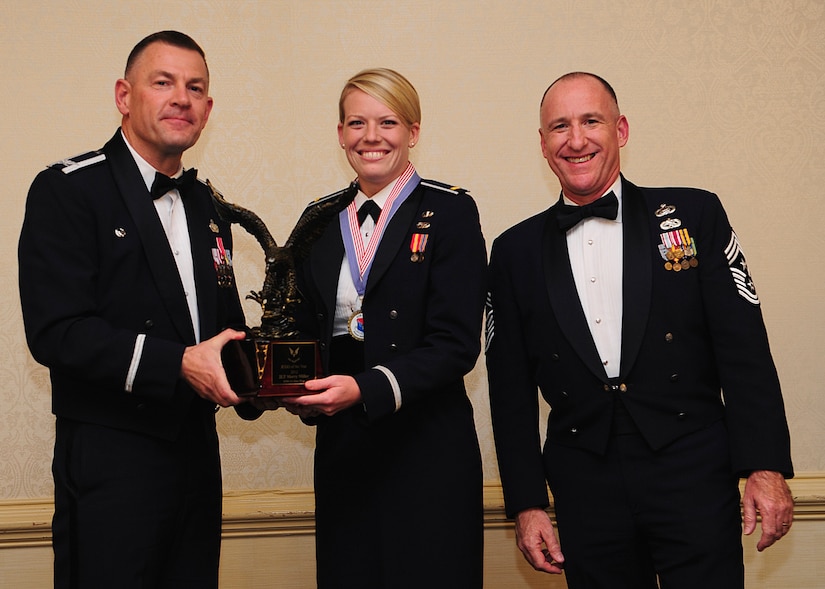 Colonel Richard McComb, Joint Base Charleston commander, and Chief Master Sgt. Al Hannon, 628th Air Base Wing command chief, present the JB Charleston Junior Grade Officer of the Year award to 2nd Lt. Merry Miller, 628th Logistics Readiness Squadron officer in charge of deployments, during the 628th ABW Annual Awards Banquet held at the Charleston Club, Jan. 25, 2013, at JB Charleston - Air Base, S.C. (U.S. Air Force photo/Staff Sgt. Rasheen Douglas)