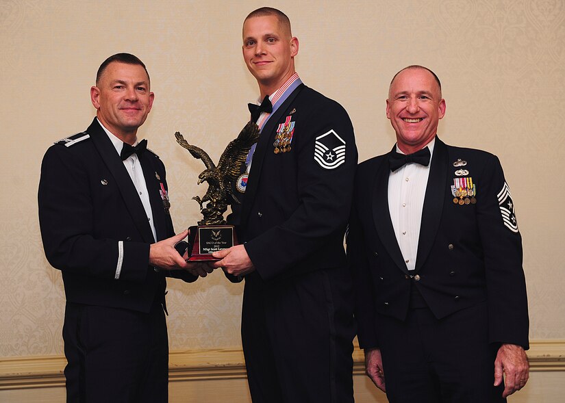 Colonel Richard McComb, Joint Base Charleston commander, and Chief Master Sgt. Al Hannon, 628th Air Base Wing command chief, present the JB Charleston Senior Noncommissioned Officer of the Year award to Master Sgt. Scott Levesque, 628th Communications Squadron plans and programs flight superintendent, during the 628th ABW Annual Awards Banquet held at the Charleston Club, Jan. 25, 2013, at JB Charleston - Air Base, S.C. (U.S. Air Force photo/Staff Sgt. Rasheen Douglas)