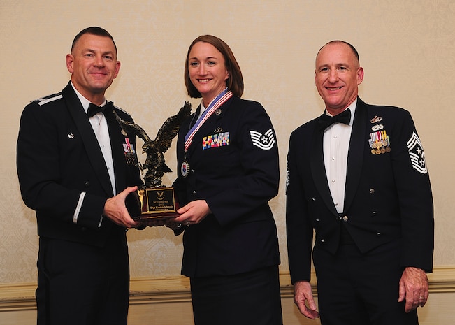 Colonel Richard McComb, Joint Base Charleston commander, and Chief Master Sgt. Al Hannon, 628th Air Base Wing command chief, present the JB Charleston Noncommissioned Officer of the Year award to Tech. Sgt. Kristen Schmalz, 628th Air Base Wing noncommissioned officer in charge of command post operation, during the 628th ABW Annual Awards Banquet held at the Charleston Club, Jan. 25, 2013, at JB Charleston - Air Base, S.C. (U.S. Air Force photo/Staff Sgt. Rasheen Douglas)