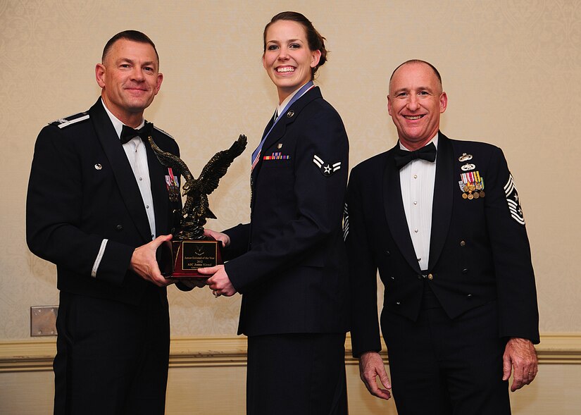 Colonel Richard McComb, Joint Base Charleston commander, and Chief Master Sgt. Al Hannon, 628th Air Base Wing command chief, present the JB Charleston Airman of the Year award to Airman 1st Class Jonna Kienzl, 628th Medical Group dental assistant, during the 628th ABW Annual Awards Banquet held at the Charleston Club, Jan. 25, 2013, at JB Charleston - Air Base, S.C. (U.S. Air Force photo/Staff Sgt. Rasheen Douglas)