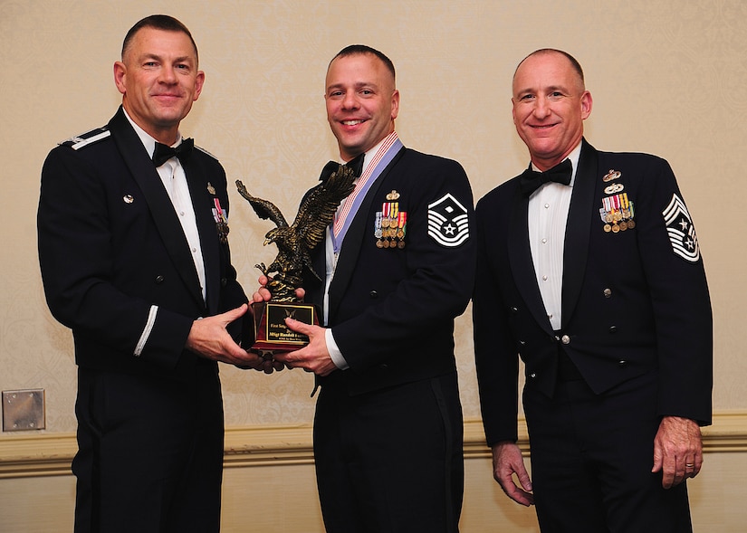 Colonel Richard McComb, Joint Base Charleston commander, and Chief Master Sgt. Al Hannon, 628th Air Base Wing command chief, present the JB Charleston First Sergeant of the Year award to Master Sgt. Randall Fontenont, 628th Civil Engineer Squadron first sergeant, during the 628th ABW Annual Awards Banquet held at the Charleston Club, Jan. 25, 2013, at JB Charleston - Air Base, S.C. (U.S. Air Force photo/Staff Sgt. Rasheen Douglas)