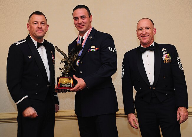 Colonel Richard McComb, Joint Base Charleston commander, and Chief Master Sgt. Al Hannon, 628th Air Base Wing command chief, present the JB Charleston Volunteer of the Year award to Senior Airman Bryan Queen, 628th Logistics Readiness Squadron fuels fixed facility supervisor, during the 628th ABW Annual Awards Banquet held at the Charleston Club, Jan. 25, 2013, at JB Charleston - Air Base, S.C. (U.S. Air Force photo/Staff Sgt. Rasheen Douglas)