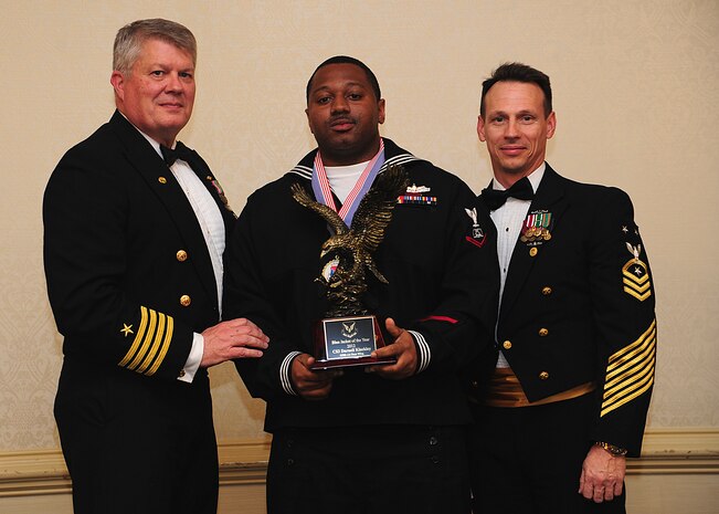 Navy Captain Thomas Bailey, Joint Base Charleston deputy commander, and Master Chief Petty Officer Billy Cady, JB Charleston – Weapons Station command master chief, present the Blue Jacket of the Year award to Petty Officer 3rd Class Darnell Kleckley, Naval Support Activity culinary specialist, at the 628th Air Base Wing Annual Awards Banquet held at the Charleston Club, Jan. 25, 2013, at JB Charleston - Air Base, S.C. (U.S. Air Force photo/Staff Sgt. Rasheen Douglas)