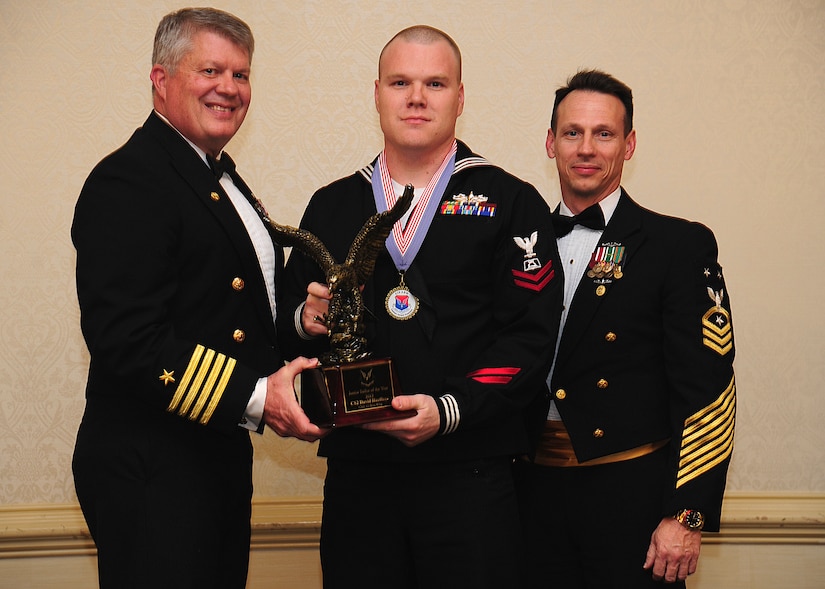 Navy Captain Thomas Bailey, Joint Base Charleston deputy commander, and Master Chief Petty Officer Billy Cady, JB Charleston – Weapons Station command master chief, present the Junior Sailor of the Year award to Petty Officer 2nd Class David Haeffner, Naval Support Activity culinary specialist, at the 628th Air Base Wing Annual Awards Banquet held at the Charleston Club, Jan. 25, 2013, at JB Charleston - Air Base, S.C. (U.S. Air Force photo/Staff Sgt. Rasheen Douglas)