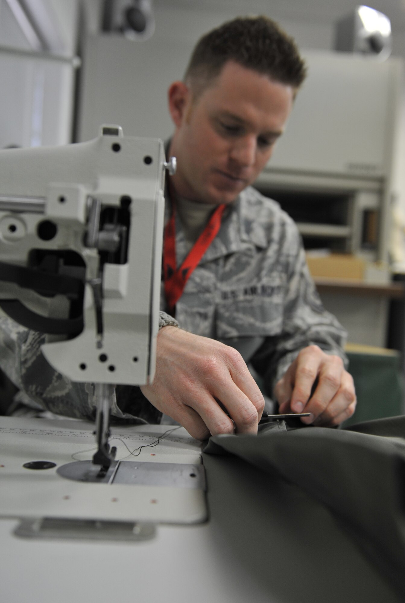 WHITEMAN AIR FORCE BASE, Mo. -- Master Sgt. Jacob Mann, 110th Bomb Squadron, Air National Guard, trims excess thread after sewing an integrated prototype cot, Jan. 18. Pilots use cots in the B-2 Spirit and other aircraft during long-duration flights. (U.S. Air Force photo/Heidi Hunt) (Released)