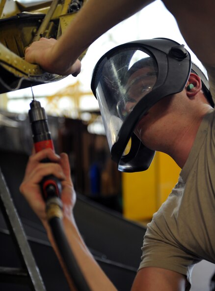 Senior Airman Dillon Dunbar, 2nd Maintenance Squadron Fabrication Flight sheet metal, drills rivets out of a lower body cowling on Barksdale Air Force Base, La., Jan. 29. Airmen from the fabrication flight repair or replace sheet metal and fix loose rivets and cracks on the B-52 aircraft. (U.S. Air Force photo/Airman 1st Class Benjamin Gonsier)