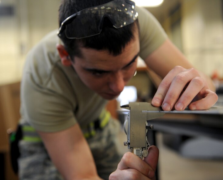 Airman Dylan Fox, 2nd Maintenance Squadron Fabrication Flight sheet metal, measures the thickness of a sheet of raw metal on Barksdale Air Force Base, La., Jan. 29. The fabrication flight makes metal parts for aircraft and repair aerospace ground equipment. (U.S. Air Force photo/Airman 1st Class Benjamin Gonsier)