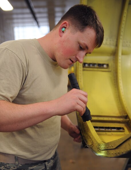 Staff Sgt. Patrick Towler, 2nd Maintenance Squadron Fabrication Flight sheet metal, inspects a lower body cowling for damage on Barksdale Air Force Base, La., Jan. 29. The lower body cowling is placed under the engine of a B-52H Stratofortress and is used to protect it from debris. (U.S. Air Force photo/Airman 1st Class Benjamin Gonsier)