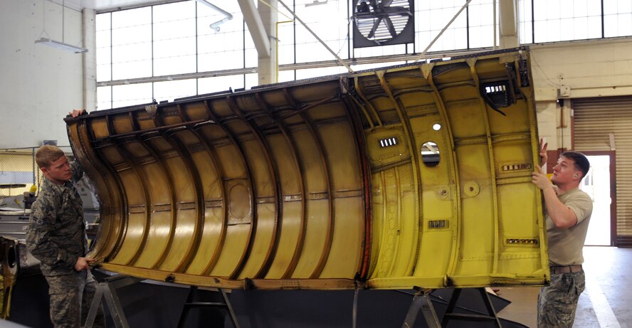 Airman 1st Class Shelby Bates and Staff Sgt. Patrick Towler, 2nd Maintenance Squadron Fabrication Flight sheet metal, turns over a lower body cowling for repairs on Barksdale Air Force Base, La., Jan. 29. The lower body cowling is placed under the engine of a B-52H Stratofortress and is used to protect it from debris. (U.S. Air Force photo/Airman 1st Class Benjamin Gonsier)