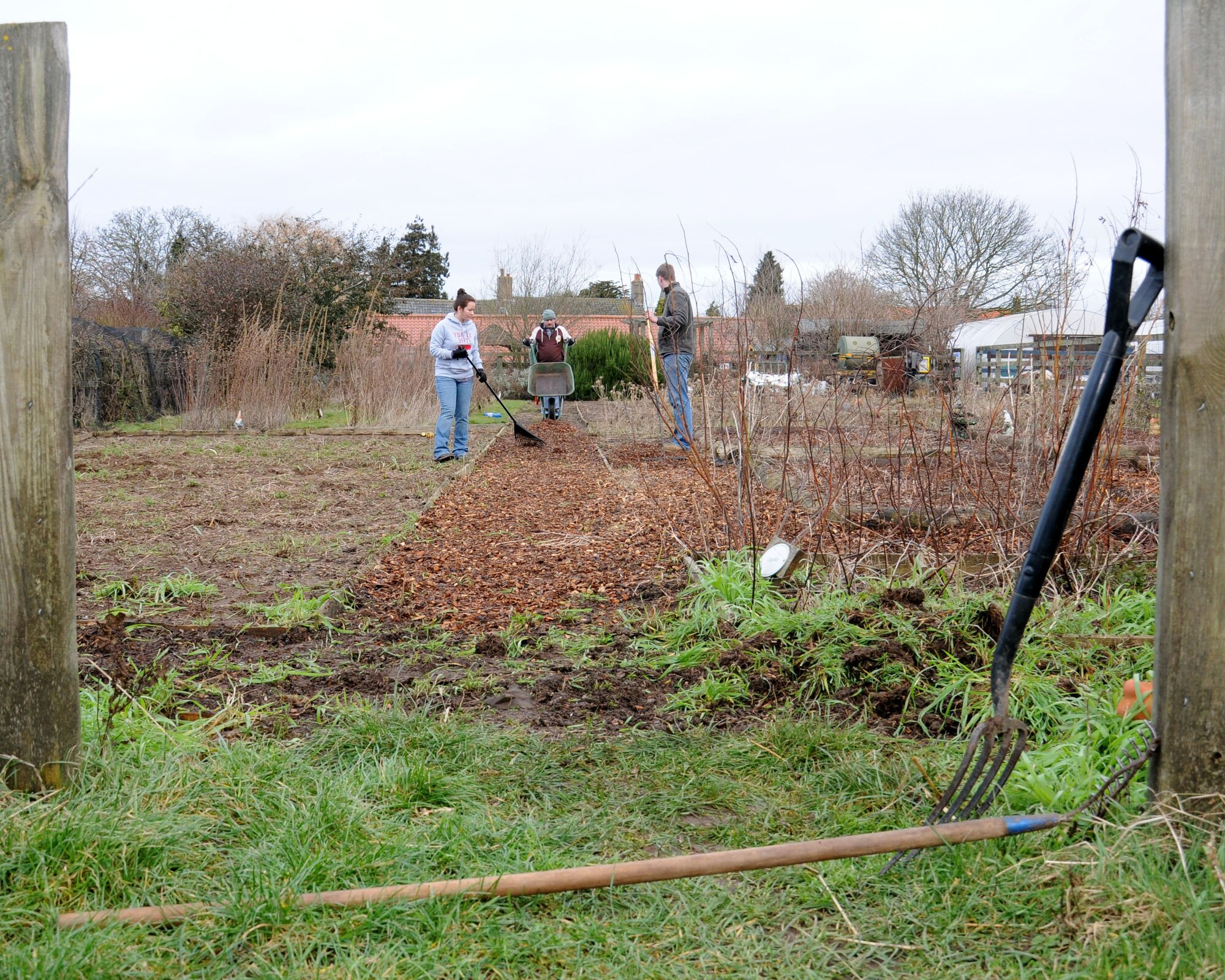 Members from the 100th Logistics Readiness Squadron lay bark while volunteering Jan. 29, 2013, at Busy Bees nursery, Beck Row, England. The squadron wanted to give back to the local community. (U.S. Air Force photo by Gina Randall/Released)