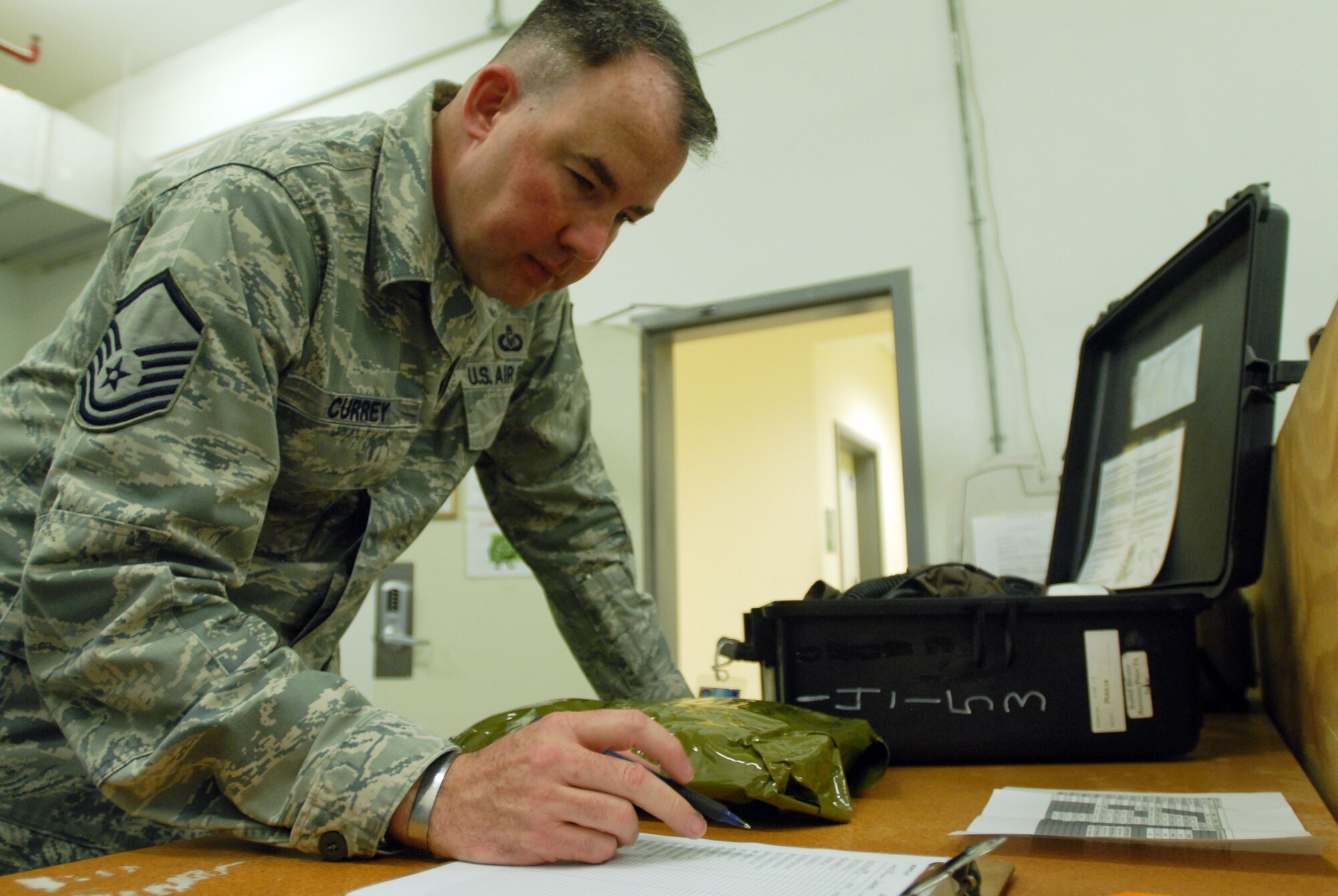 SOUTHWEST ASIA -- Master Sgt. Gregory Currey, superintendent, performs a quality control inspection on a chemical defense ensemble used by aircrews. The 816th Expeditionary Airlift Squadron Aircrew Flight Equipment office maintains life-saving equipment for pilots and loadmasters on the C-17A Globemaster III at an undisclosed location Southwest Asia.(U.S. Air Force photo/Master Sgt. Christian Michael)
