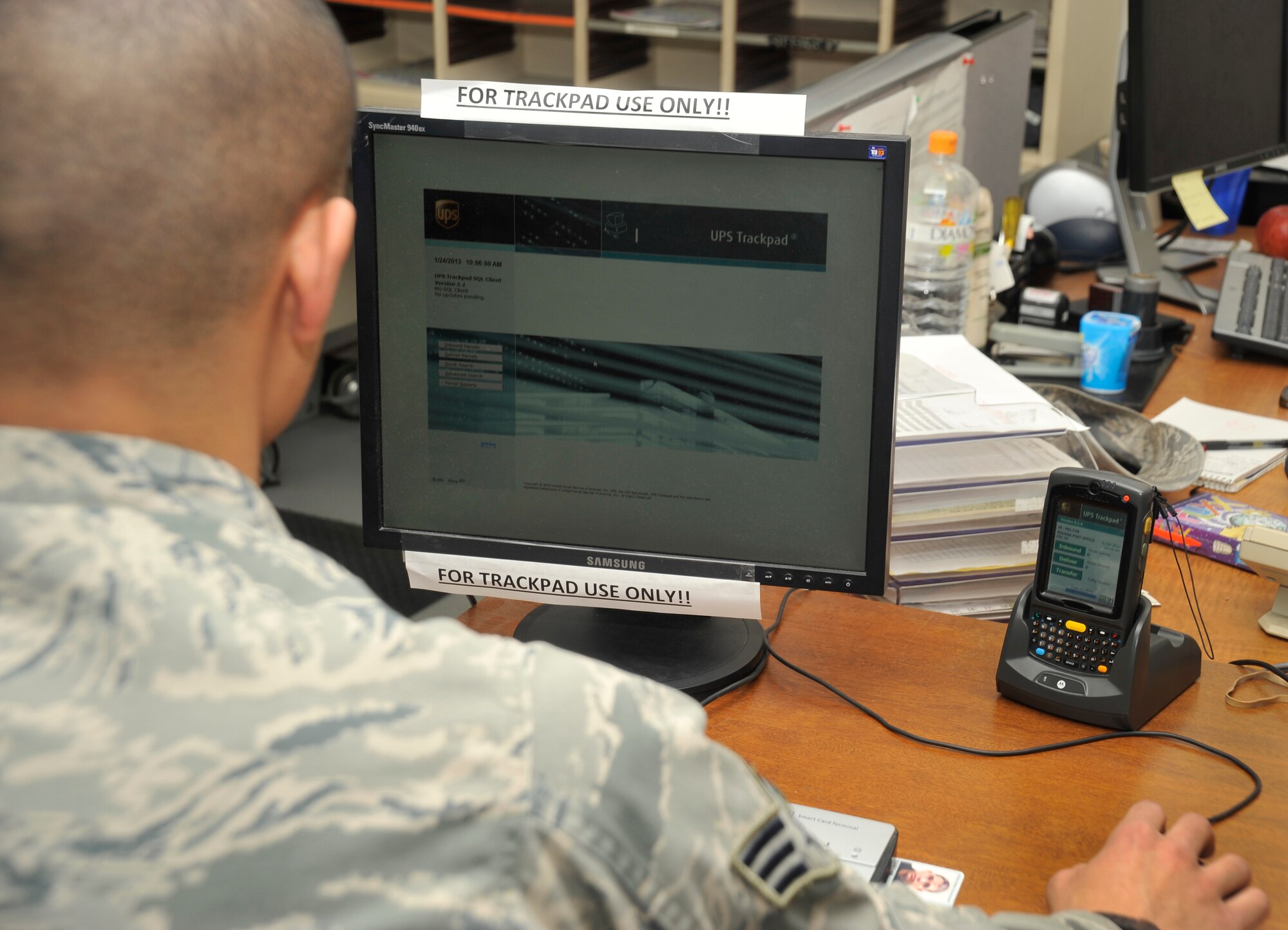 U.S. Air Force Senior Airman Marc Bates, 35th Communications Squadron postal clerk, logs into the post office’s Trackpad designated computer at Misawa Air Base, Japan, Jan. 24, 2013. By plugging the handheld device into the computer, email notifications will be sent out to customers that have provided a valid email address to the customer service counter. (U.S. Air Force photo by Airman 1st Class Zachary Kee)