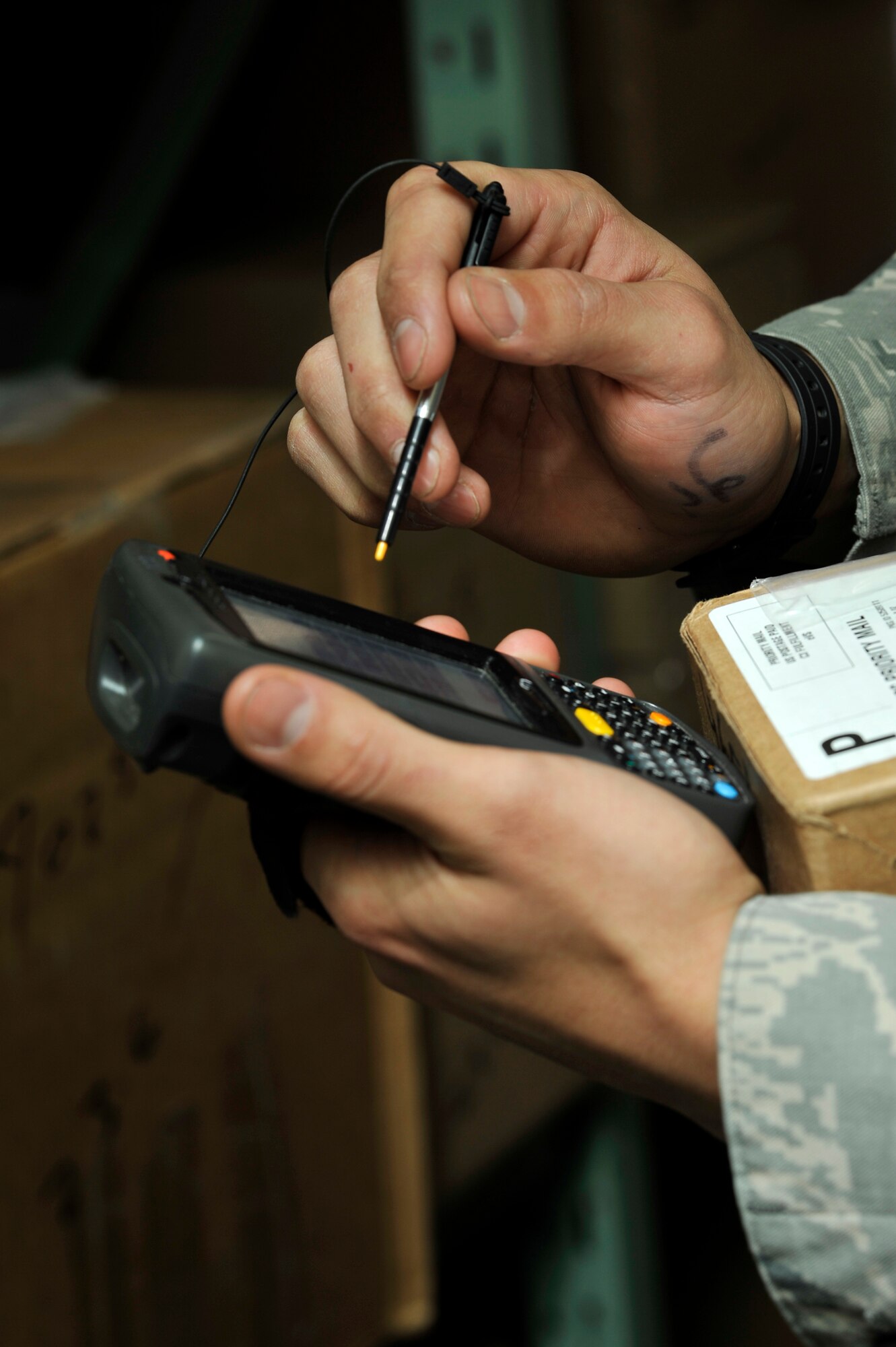 U.S. Air Force Senior Airman Marc Bates, 35th Communications Squadron postal clerk, matches a customer’s mailbox information to the name on the package at Misawa Air Base, Japan, Jan. 24, 2013. With the new upgrade, the post office can save time and manpower by switching to their new handheld devices. (U.S. Air Force photo by Airman 1st Class Zachary Kee)