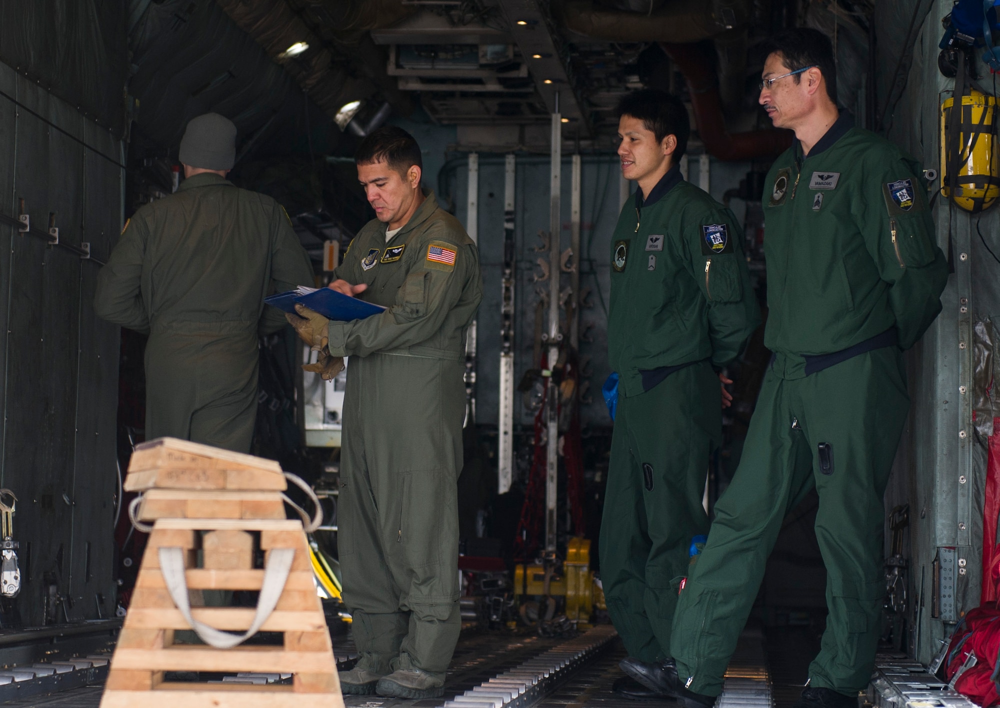 YOKOTA AIR BASE, Japan --1st Lt. Stephen Elliott, 36th Airlift Squadron, walks with Japan Air Self-Defense Force aircrew Komaki Air Base, Japan, to a C-130 Hercules aircraft at Yokota Air Base, Japan, Jan. 9, 2013. During the visit, the JASDF aircrew tagged alongside their U.S. aircrew counterparts from the 36 AS for their pre-flight briefings and inspections, comparing operational practices and professional airlift strategies with their own. (U.S. Air Force photo by Senior Airman Andrea Salazar)