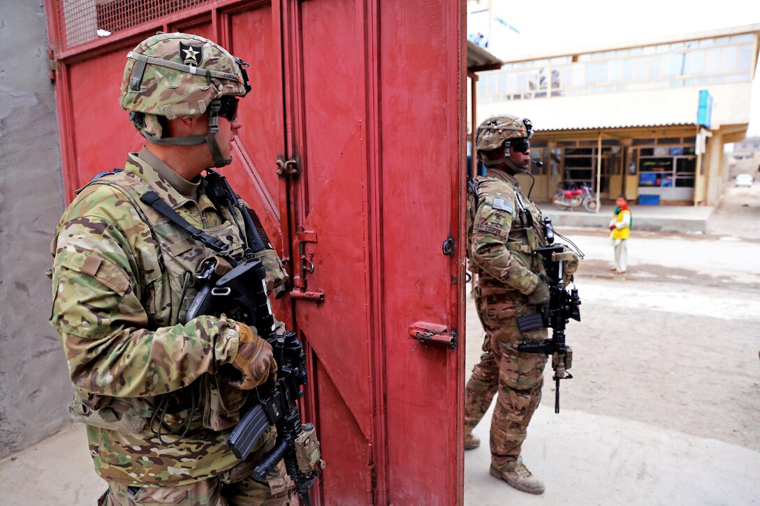 U.S. Army Spc. Michael Jones, left, and U.S. Army Staff Sgt. Roderick Cooper prepare for a dismounted patrol outside the Directorate of Information and Culture building in Farah City, Afghanistan, Jan. 30, 2013. Jones and Cooper are assigned to Provincial Reconstruction Team Farah.