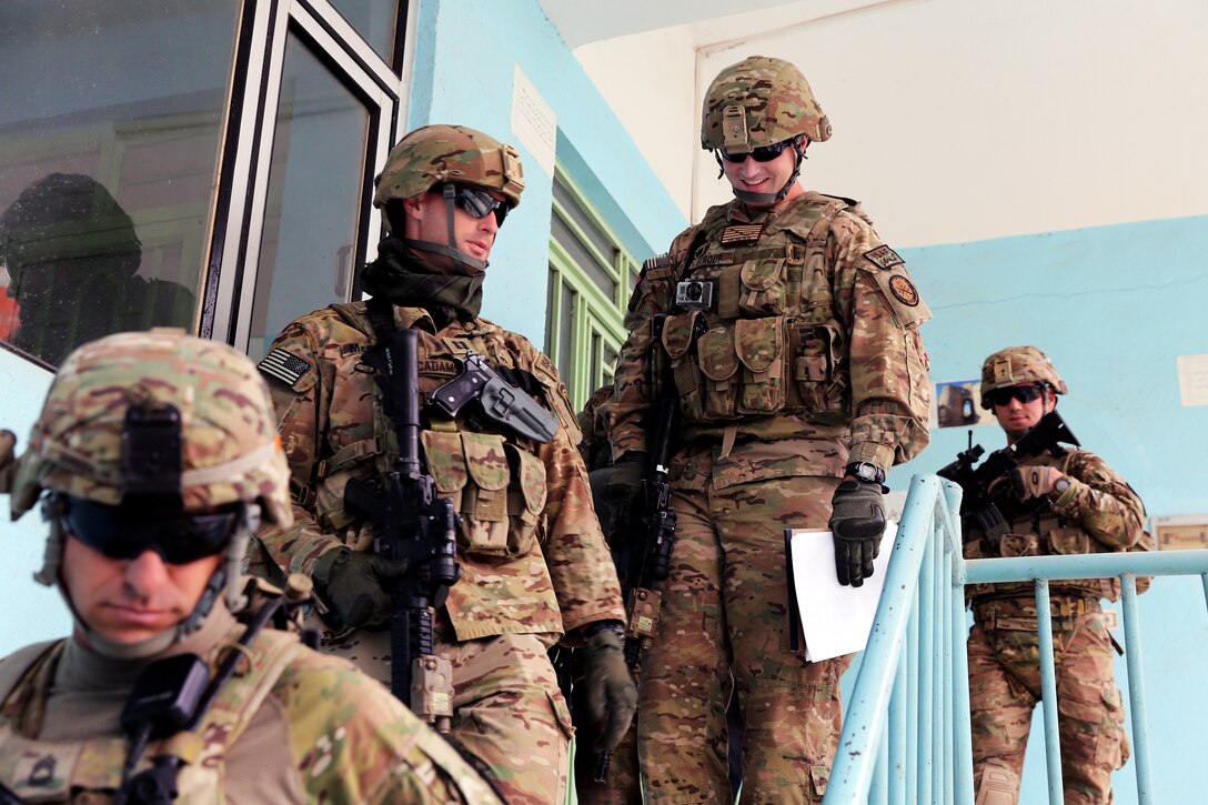 U.S. Army Capt. Garrett McAdams, left, and U.S. Navy Lt. j.g. Matthew Stroup, right, depart the Directorate of Information and Culture building after completing photojournalism training in Farah City, Afghanistan, Jan. 30, 2013. McAdams, a civil affairs officer, and Stroup, a public affairs officer, are assigned to Provincial Reconstruction Team Farah.
