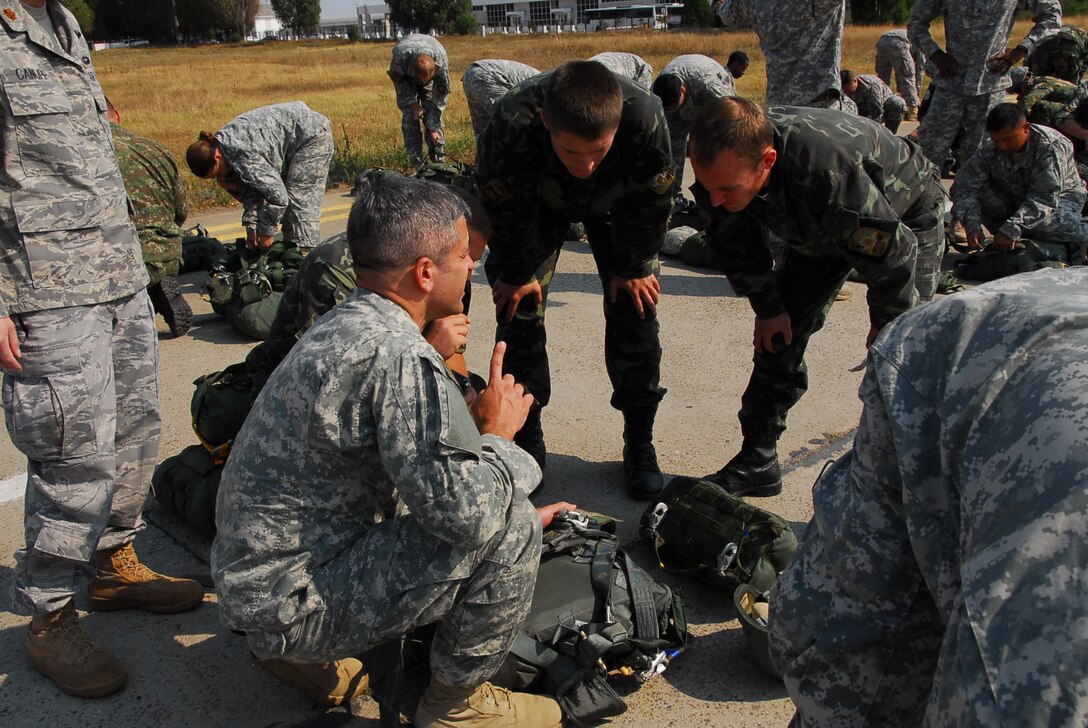 U.S. Army Lt. Col. Antonio Paz, left, a military intelligence officer within Special Operations Command Europe, goes through jumpmaster pre-inspection with Ukranian parachutists for a multinational fun jump during exercise Jackal Stone 2011 at Mihail Kogalniceanu Air Base, Romania, Sept. 15, 2011. Jackal Stone is an annual joint special operations exercise designed to enhance capabilities and interoperability amongst the participating special operations forces as well as to build mutual respect while sharing doctrinal concepts, training concepts and various tactics, techniques and procedures.