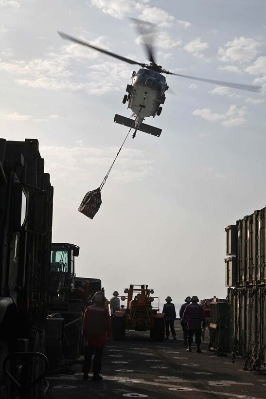 A MH-60S Knighthawk with Helicopter Combat Squadron 23 conducts a vertical replenishment from the USNS Bridge to the USS Rushmore during a replenishment-at-sea, Jan. 21. The 15th Marine Expeditionary Unit is deployed as part of the Peleliu Amphibious Ready Group as a U.S. Central Command theater reserve force, providing support for maritime security operations and theater security cooperation efforts in the U.S. 5th Fleet area of responsibility. (U.S. Marine Corps photo by Cpl. Timothy R. Childers)