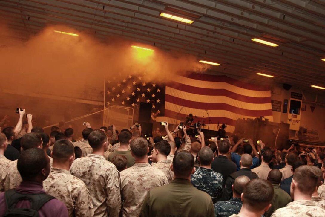Marines and sailors with the 15th Marine Expeditionary Unit and Peleliu Amphibious Ready Group enjoy themselves at an Anberlin concert held in the hangar bay of the USS Peleliu, Jan. 21. Anberlin, a rock band from the United States, spent more than 20 hours traveling to see the deployed Marines and sailors of the 15th MEU and Peleliu ARG, Jan. 21-22. The visit included a musical performance as well as a tour of the ship and its amenities. The 15th MEU is deployed as part of the Peleliu ARG as a U.S. Central Command theater reserve force, providing support for maritime security operations and theater security cooperation efforts in the U.S. 5th Fleet area of responsibility. (U.S. Marine Corps photo by Cpl. John Robbart III)