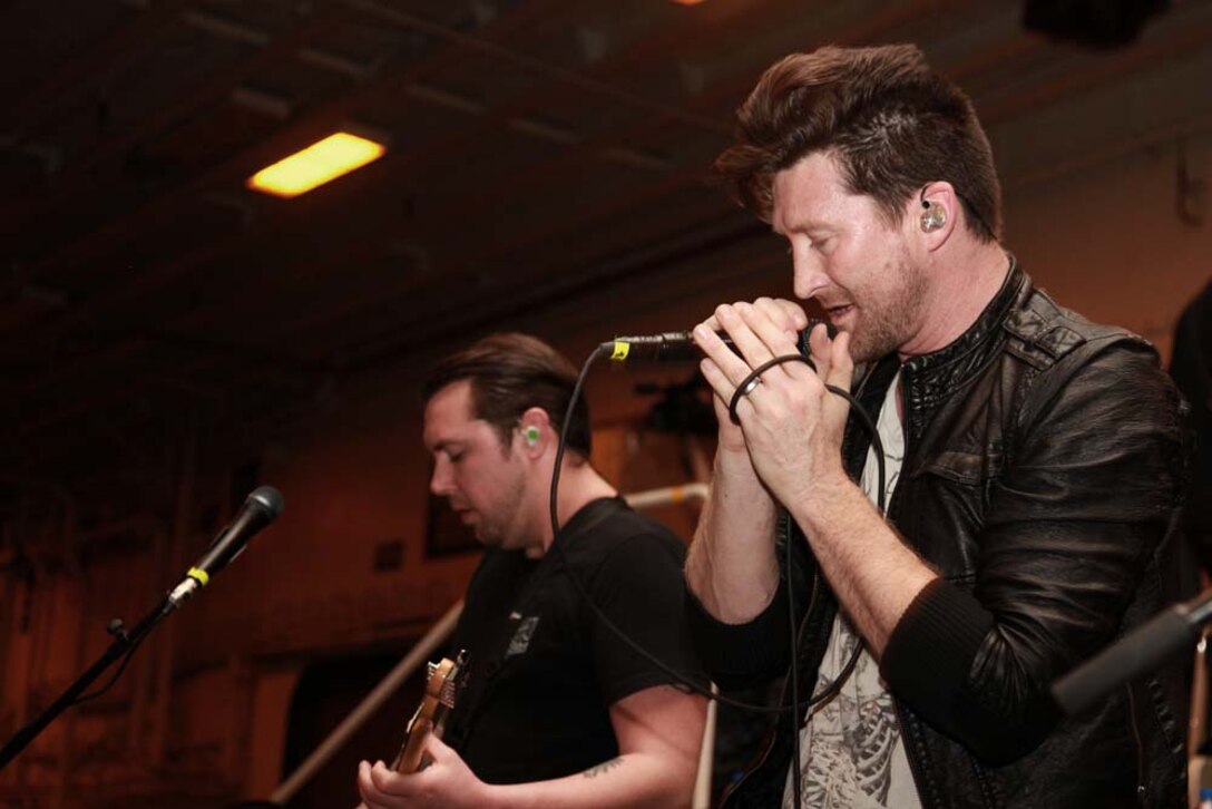 Stephen Christian, Anberlin's lead singer, performs for the Marines and sailors of the 15th Marine Expeditionary Unit and Peleliu Amphibious Ready Group during an Anberlin concert held in the hangar bay of the USS Peleliu, Jan. 21. Anberlin, a rock band from the United States, spent more than 20 hours traveling to see the deployed Marines and sailors of the 15th MEU and Peleliu ARG, Jan. 21-22. The visit included a musical performance as well as a tour of the ship and its amenities. The 15th MEU is deployed as part of the Peleliu ARG as a U.S. Central Command theater reserve force, providing support for maritime security operations and theater security cooperation efforts in the U.S. 5th Fleet area of responsibility. (U.S. Marine Corps photo by Cpl. John Robbart III)