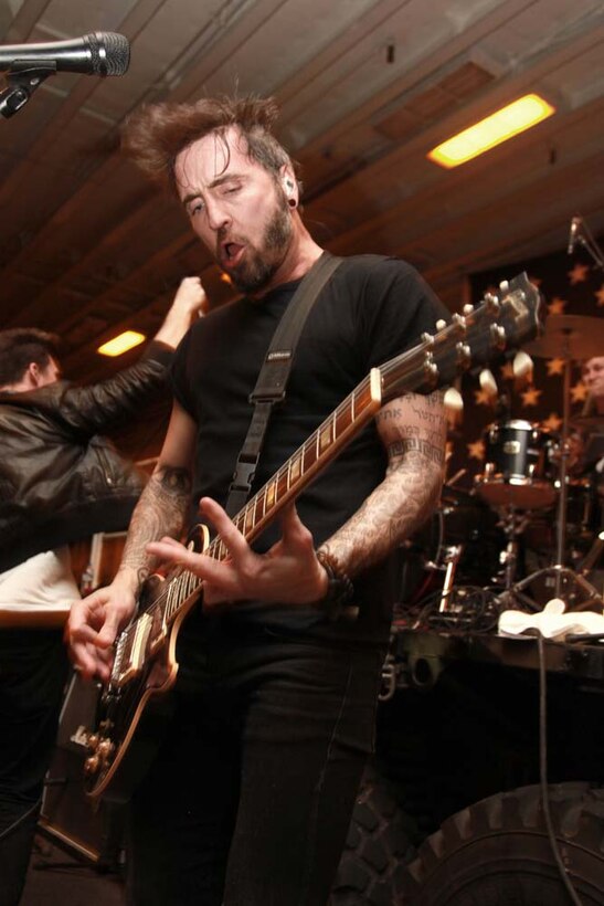 Christian McAlhaney, a guitarist with the band Anberlin, performs for the Marines and sailors of the 15th Marine Expeditionary Unit and Peleliu Amphibious Ready Group during an Anberlin concert held in the hangar bay of the USS Peleliu, Jan. 21. Anberlin, a rock band from the United States, spent more than 20 hours traveling to see the deployed Marines and sailors of the 15th MEU and Peleliu ARG, Jan. 21-22. The visit included a musical performance as well as a tour of the ship and its amenities. The 15th MEU is deployed as part of the Peleliu ARG as a U.S. Central Command theater reserve force, providing support for maritime security operations and theater security cooperation efforts in the U.S. 5th Fleet area of responsibility. (U.S. Marine Corps photo by Cpl. John Robbart III)