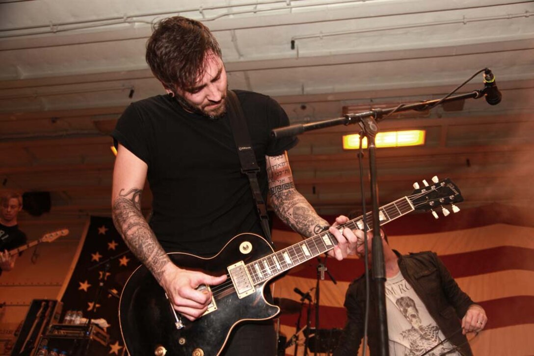 Christian McAlhaney, a guitarist with the band Anberlin, performs for the Marines and sailors of the 15th Marine Expeditionary Unit and Peleliu Amphibious Ready Group during an Anberlin concert held in the hangar bay of the USS Peleliu, Jan. 21. Anberlin, a rock band from the United States, spent more than 20 hours traveling to see the deployed Marines and sailors of the 15th MEU and Peleliu ARG, Jan. 21-22. The visit included a musical performance as well as a tour of the ship and its amenities. The 15th MEU is deployed as part of the Peleliu ARG as a U.S. Central Command theater reserve force, providing support for maritime security operations and theater security cooperation efforts in the U.S. 5th Fleet area of responsibility. (U.S. Marine Corps photo by Cpl. John Robbart III)