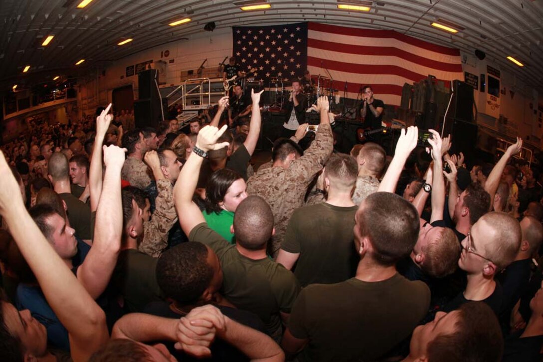 Marines and sailors with the 15th Marine Expeditionary Unit and Peleliu Amphibious Ready Group enjoy themselves at an Anberlin concert held in the hangar bay of the USS Peleliu, Jan. 21. Anberlin, a rock band from the United States, spent more than 20 hours traveling to see the deployed Marines and sailors of the 15th MEU and Peleliu ARG, Jan. 21-22. The visit included a musical performance as well as a tour of the ship and its amenities. The 15th MEU is deployed as part of the Peleliu ARG as a U.S. Central Command theater reserve force, providing support for maritime security operations and theater security cooperation efforts in the U.S. 5th Fleet area of responsibility. (U.S. Marine Corps photo by Cpl. John Robbart III)