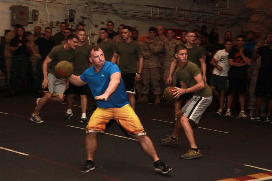 Marines with the 15th Marine Expeditionary Unit throw dodgeballs at their opponents during a dodgeball tournament held in the hangar bay of the USS Peleliu, Jan. 24. The dodgeball challenge was the eighth competition of the Campbell Cup, a bi-monthly challenge that pits teams within the 15th Marine Expeditionary Unit and Peleliu Amphibious Ready Group against each other. The 15th MEU is deployed as part of the Peleliu ARG as a U.S. Central Command theater reserve force, providing support for maritime security operations and theater security cooperation efforts in the U.S. 5th Fleet area of responsibility. (U.S. Marine Corps photo by Cpl. John Robbart III/Released)