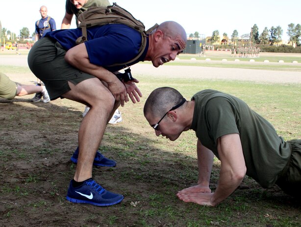 Staff Sgt. Gilbert Diaz a drill instructor with Company L, 3rd Recruit Training Battalion, encourages a recruit to give max effort during the physical training session Jan. 28.  