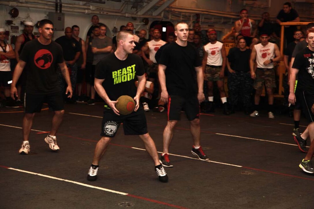 Corporal Wesley A. Barrett, scout observer, Command Element, 15th Marine Expeditionary Unit, throws a dodgeball at his opponents during a dodgeball tournament held in the hangar bay of the USS Peleliu, Jan. 24. The dodgeball challenge was the eighth competition of the Campbell Cup, a bi-monthly challenge that pits teams within the 15th Marine Expeditionary Unit and Peleliu Amphibious Ready Group against each other. The 15th MEU is deployed as part of the Peleliu ARG as a U.S. Central Command theater reserve force, providing support for maritime security operations and theater security cooperation efforts in the U.S. 5th Fleet area of responsibility. Barrett, 21, is from Wood River, Ill. (U.S. Marine Corps photo by Cpl. John Robbart III/Released)