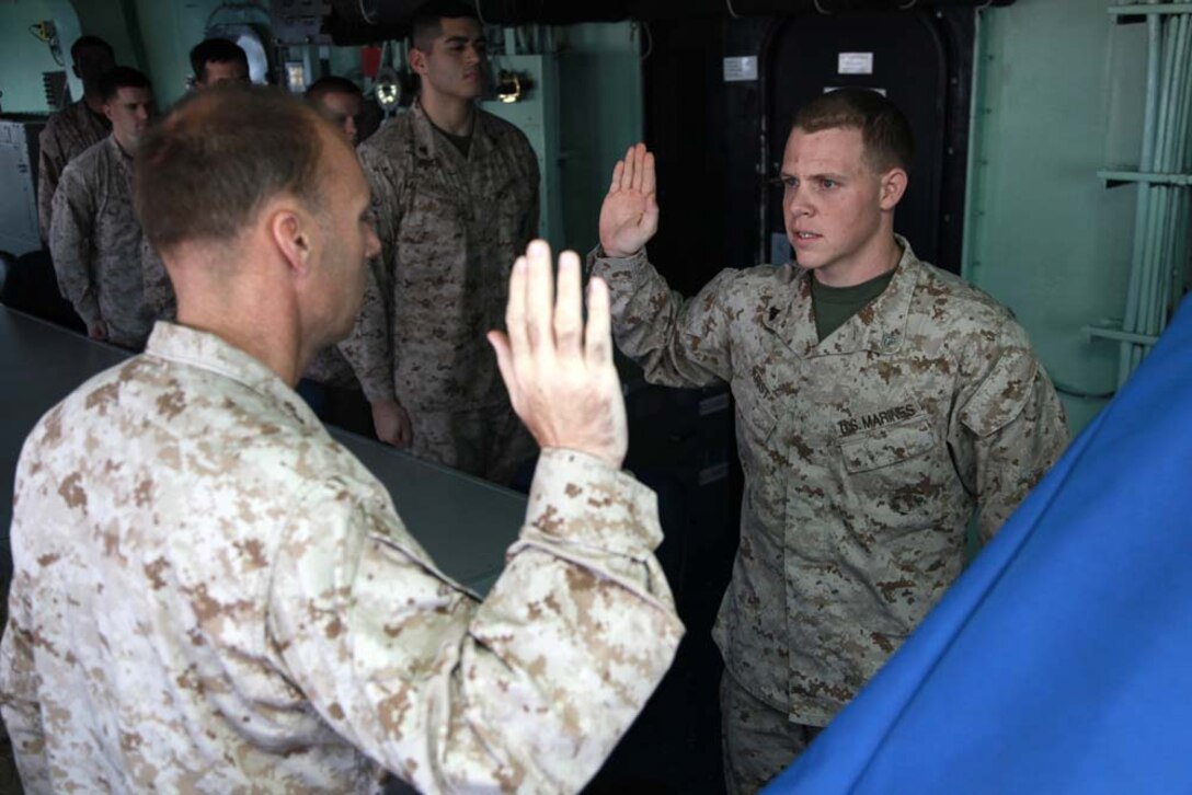 Cpl. Martin B. Krist, administrative specialist, Operations Section, re-enlists under the authority of Lt. Col. William Wischmeyer, operations officer, both with the 15th Marine Expeditionary Unit, on the bridge of the USS Peleliu, Jan. 28. The 15th MEU is deployed as part of the Peleliu Amphibious Ready Group as a U.S. Central Command theater reserve force, providing support for maritime security operations and theater security cooperation efforts in the U.S. 5th Fleet area of responsibility. Krist, 22, is from Aurora Calif. (U.S. Marine Corps photo by Cpl. John Robbart III)