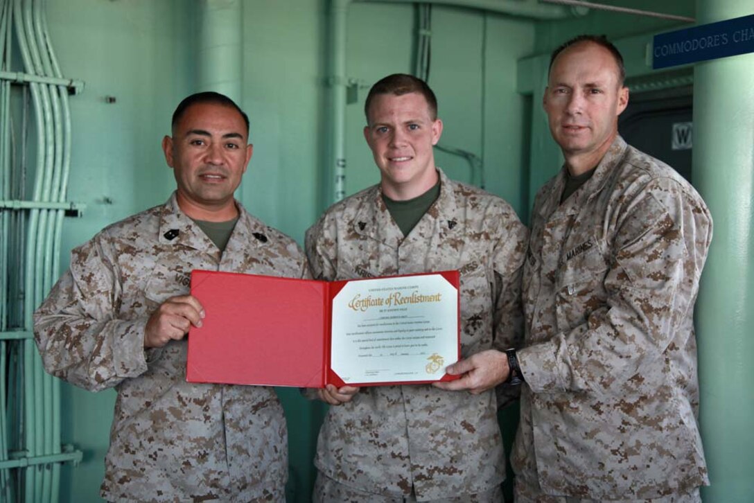 (Left to right) Master Gunnery Sgt. Tommy J. Vigil, operations chief; Cpl. Martin B. Krist, administrative specialist; Lt. Col. William Wischmeyer, operations officer; all with the Operations Section of the 15th Marine Expeditionary Unit, pose for a photo after Krist's re-enlistment on the bridge of the USS Peleliu, Jan. 28. The 15th MEU is deployed as part of the Peleliu Amphibious Ready Group as a U.S. Central Command theater reserve force, providing support for maritime security operations and theater security cooperation efforts in the U.S. 5th Fleet area of responsibility. Krist, 22, is from Aurora Calif. (U.S. Marine Corps photo by Cpl. John Robbart III)