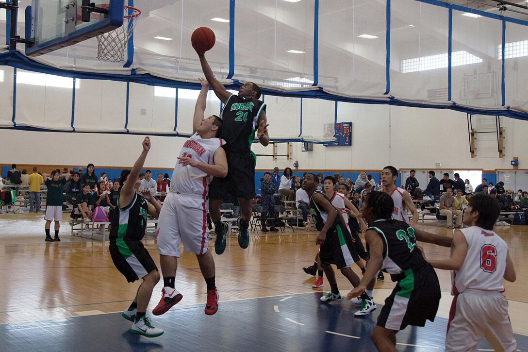 Tristen McElroy, No. 20 of the Kubasaki Dragons, leaps toward the rim for a layup against the Ginowan Red Hawks Jan. 26 during the opening round of the Okinawan-American Friendship Basketball Tournament 2013 at Risner Gym on Kadena Air Base. The Dragons narrowly won their game against the Red Hawks and took home the third-place trophy for the tournament. 