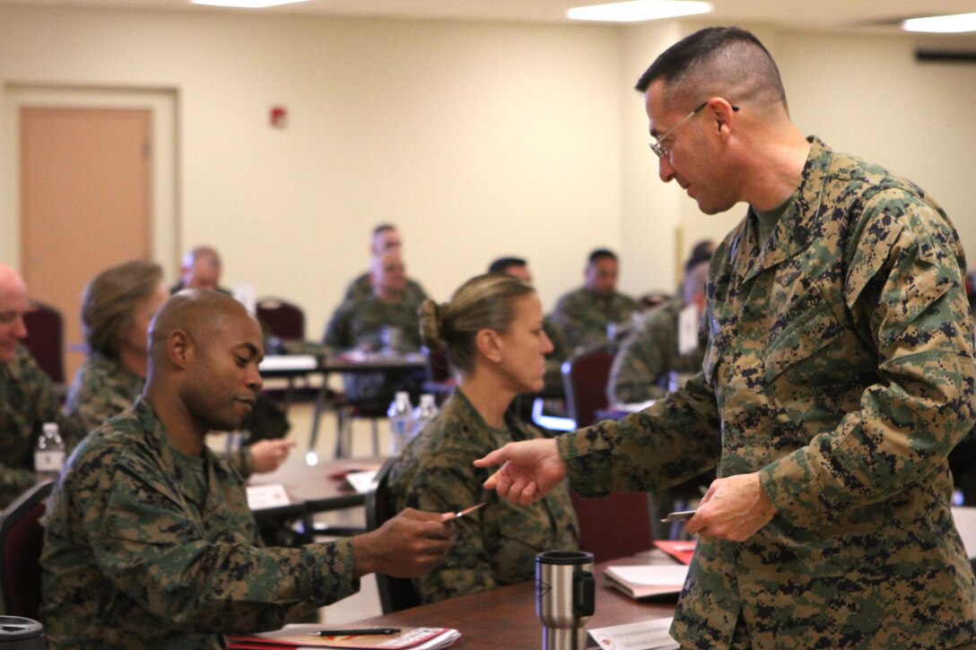 Sgt. Maj. Anthony A. Spadaro, sergeant major of 3rd Marine Aircraft Wing, hands out Corps Values cards at the Sergeants Major Symposium aboard Marine Corps Air Station Miramar, Calif., Jan. 17.  The two-day symposium gathered senior enlisted leaders of the air wing to share ideas and improve leadership skills, as part of the Committed and Engaged Leadership Campaign. 