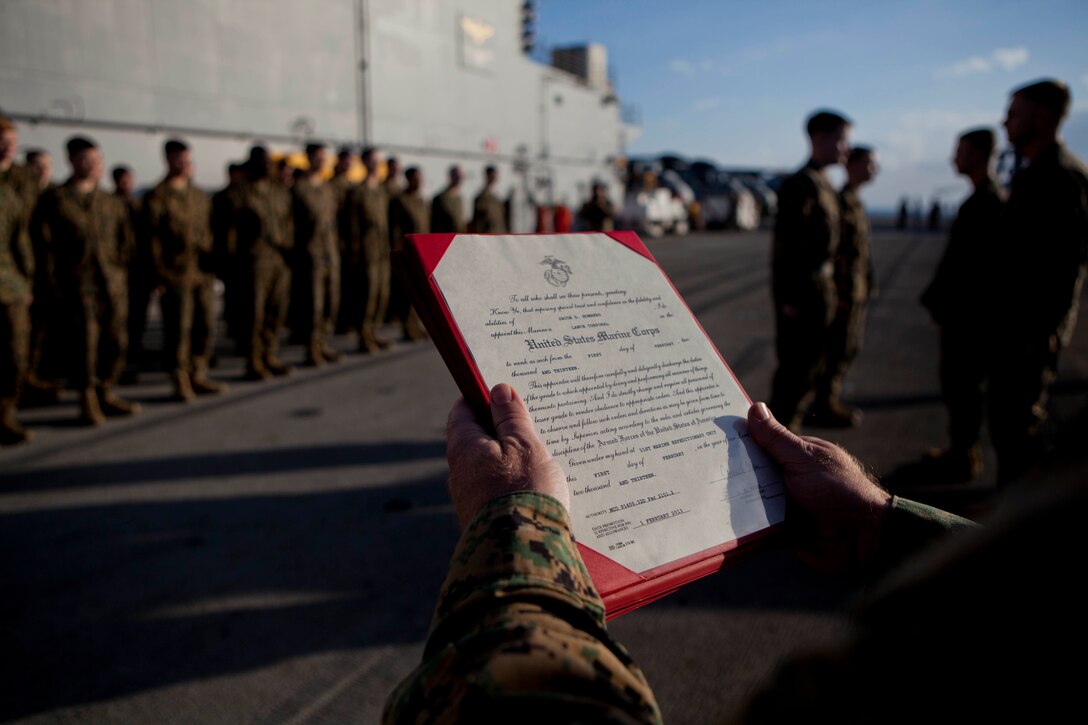 A warrant is read for one of many Marines and Sailors with the 31st Marine Expeditionary Unit to be promoted on the flight deck here, Feb. 1. The 31st MEU is currently deployed as part of its annual Spring Patrol and will soon be participating in the multinational excercise Cobra Gold 2013. The 31st MEU is the Marine Corps' force in readiness for the Asia Pacific region and the only continuously forward-deployed MEU.