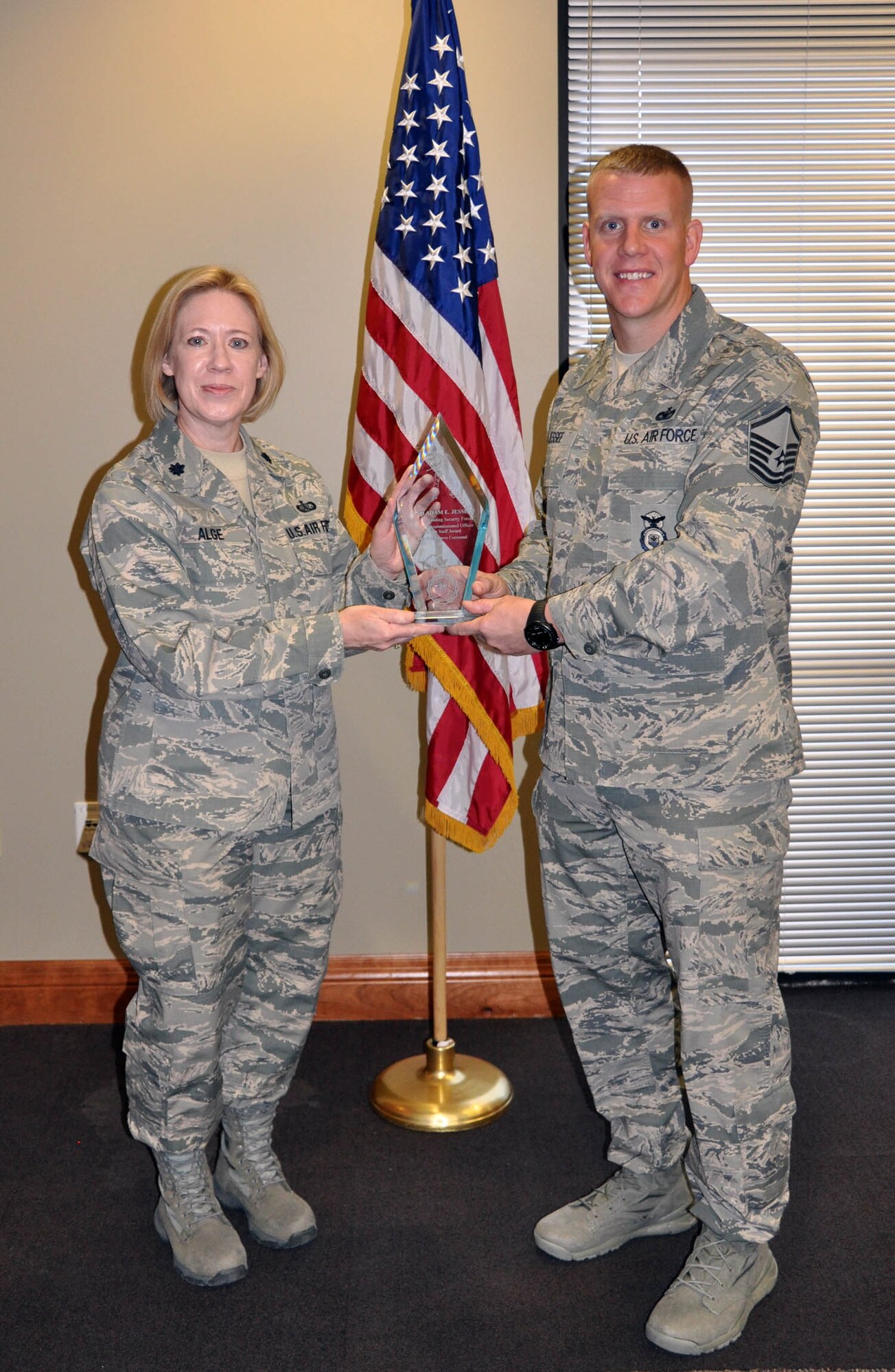 (Right) Master Sgt. Adam Jessee, 926th Security Forces Flight squad leader, receives Air Force Reserve Command's 2012 Outstanding Security Forces Senior Noncommissioned Officer Support Staff award from Lt. Col. Connie Alge, 926th Force Support Squadron commander, here Jan. 31. Jessee was recognized for managing a Regular Air Force standards and evaluation program that certified more than 500 personnel across four units, raising compliance 60 percent. Additionally, he developed a tracking database that processed 233 reports, cutting late reports by 30 percent. Jessee is also certified by the Las Vegas Metropolitan Police Department to instruct personnel on Standard Field Sobriety Tests, among many other accomplishments. (U.S. Air Force photo/Maj. Jessica Martin)