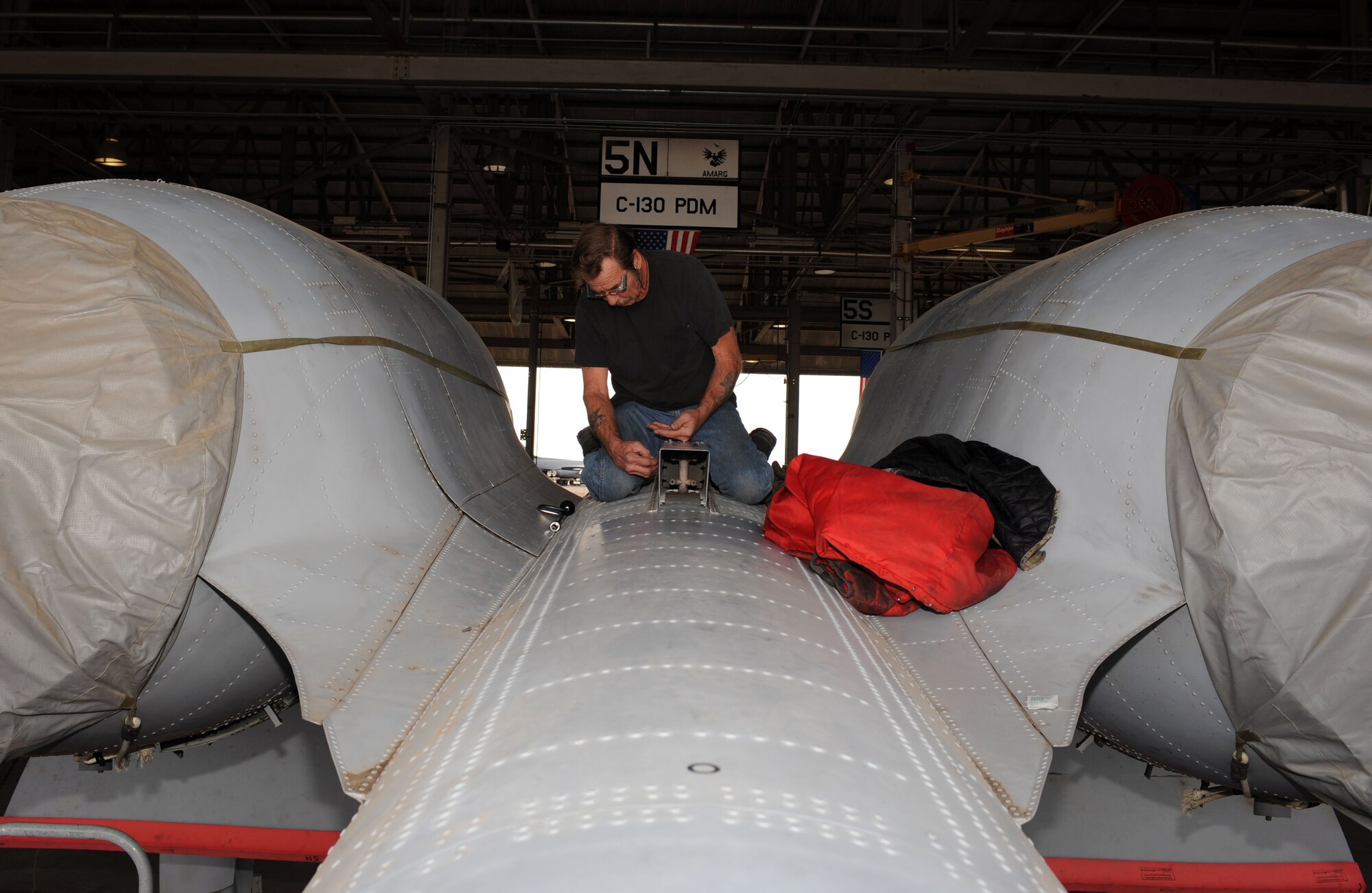 Kenneth Thompson, 576th Aerospace Maintenance and Regeneration Squadron aircraft mechanic, aligns a portion of the pre-cooler ram air duct onto the top of an A-10A Thunderbolt on Davis-Monthan Air Force Base, Ariz., Jan. 23, 2013. The 309th Aerospace Maintenance and Regeneration Group is regenerating the aircraft, which was used as a trainer for munitions load crews, so that it can be converted into a storm chaser. (U.S. Air Force photo by Senior Airman Timothy Moore/Released)